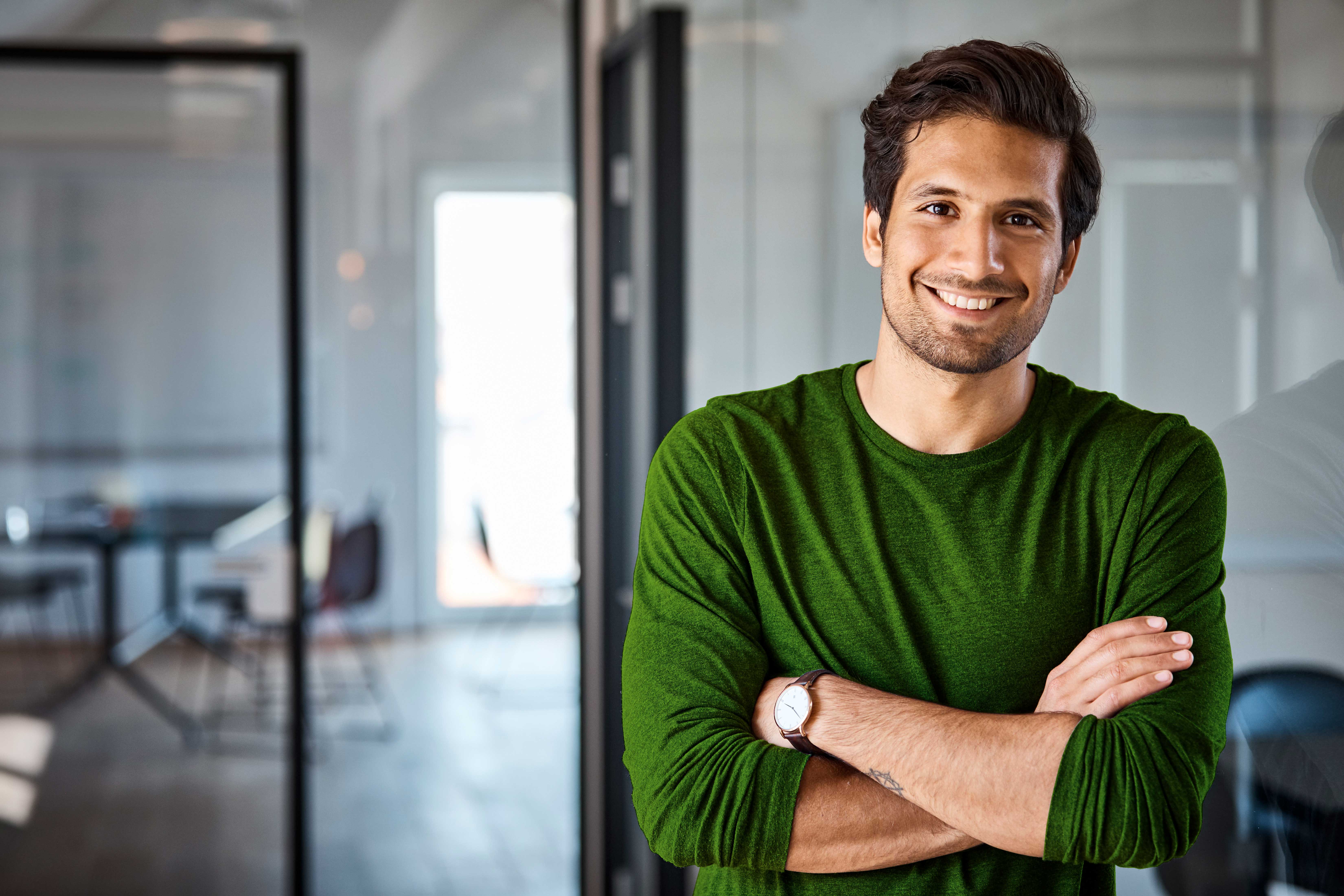 Wiesen , Bäume und ein Ort mit Kirchturm.