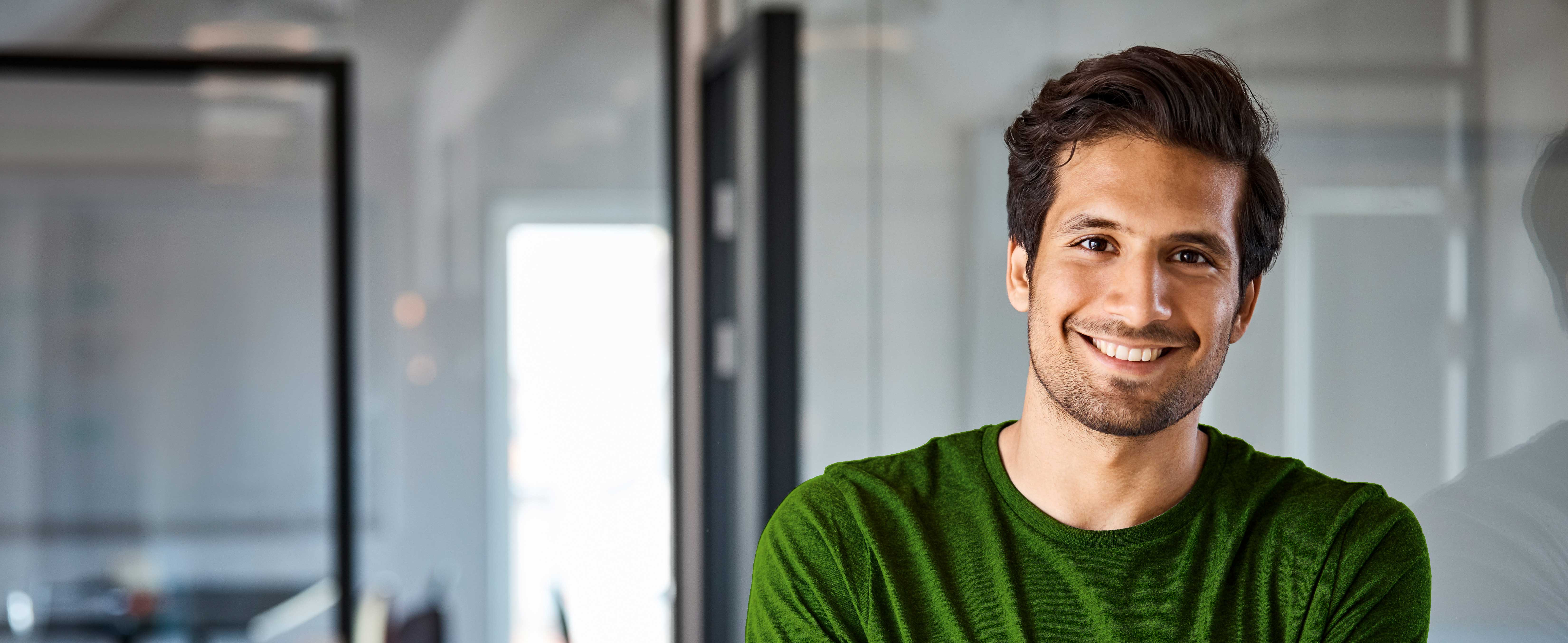 Wiesen , Bäume und ein Ort mit Kirchturm.